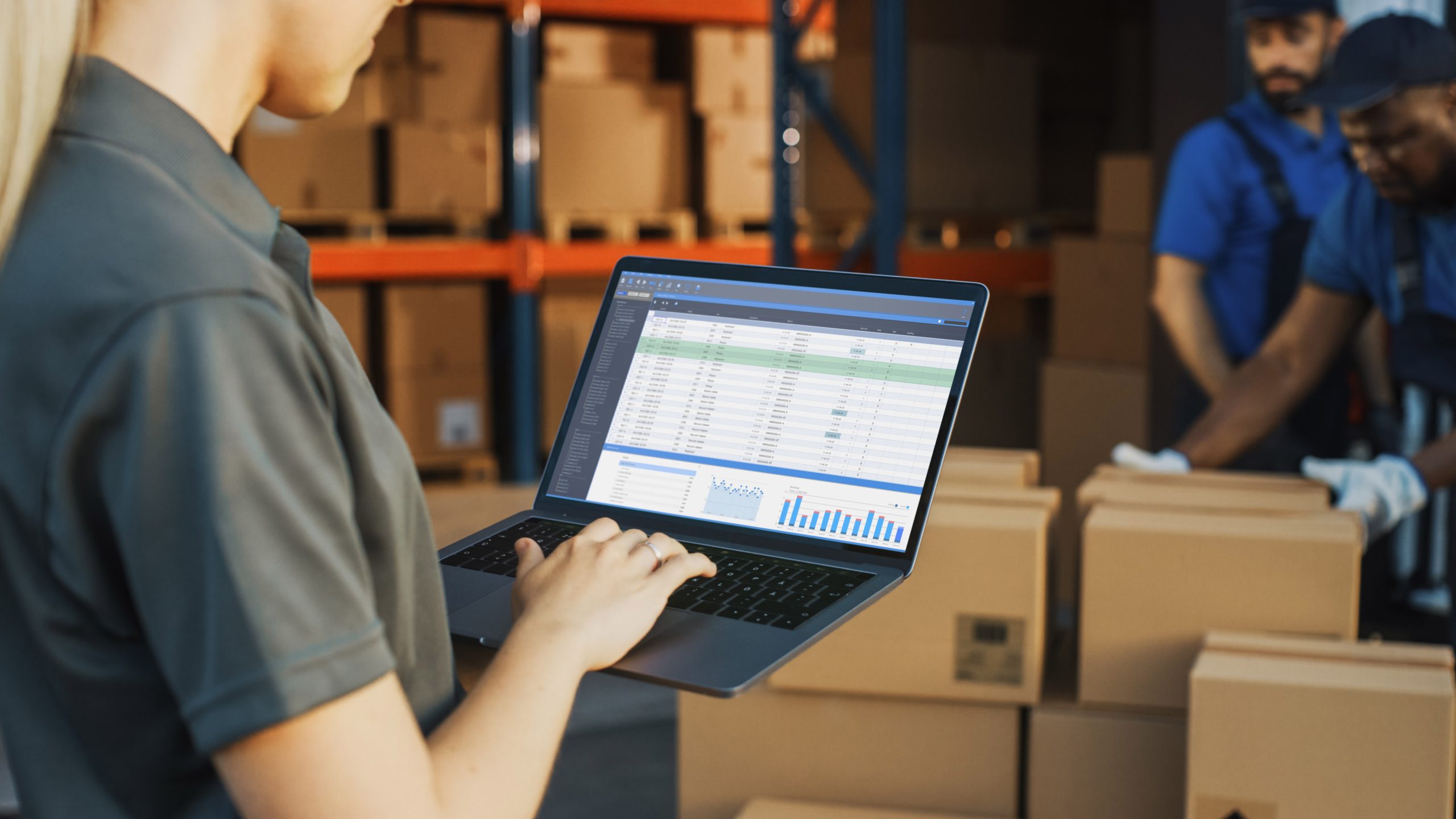 Female shipping manager uses laptop comouter to check inventory levels