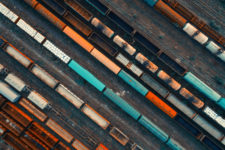 Aerial view of colorful freight trains and shipping containers on train tracks