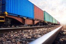 View from the ground of a freight train with colorful cargo containers