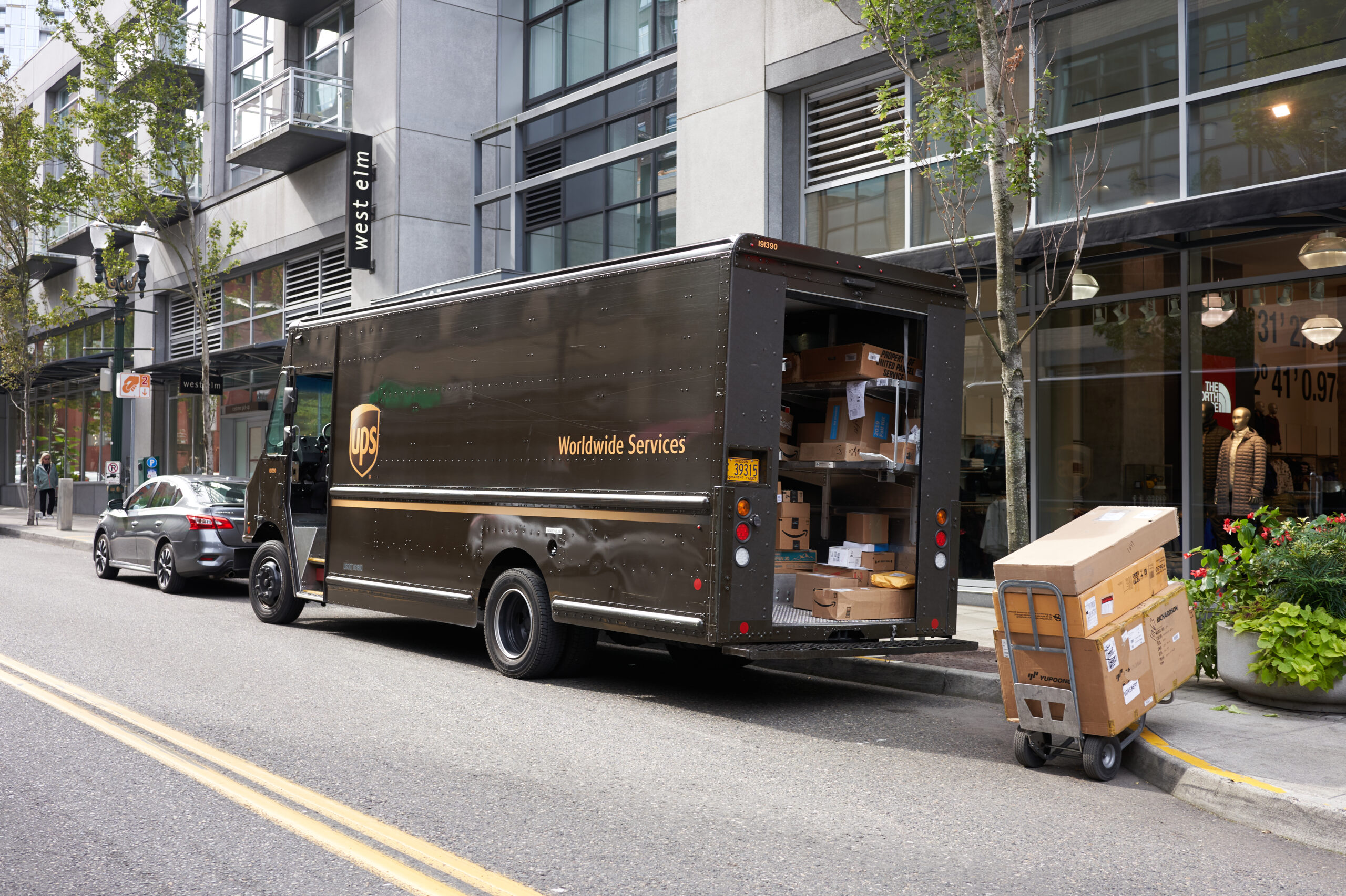 UPS driver delivering large additional handling packages