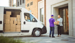 Fedex delivery man hands package to recipient