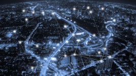 Aerial view of a city at night with a connected UPS and FedEx API concept