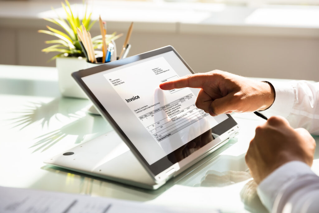 A person scrolls through an invoice on a tablet or laptop.