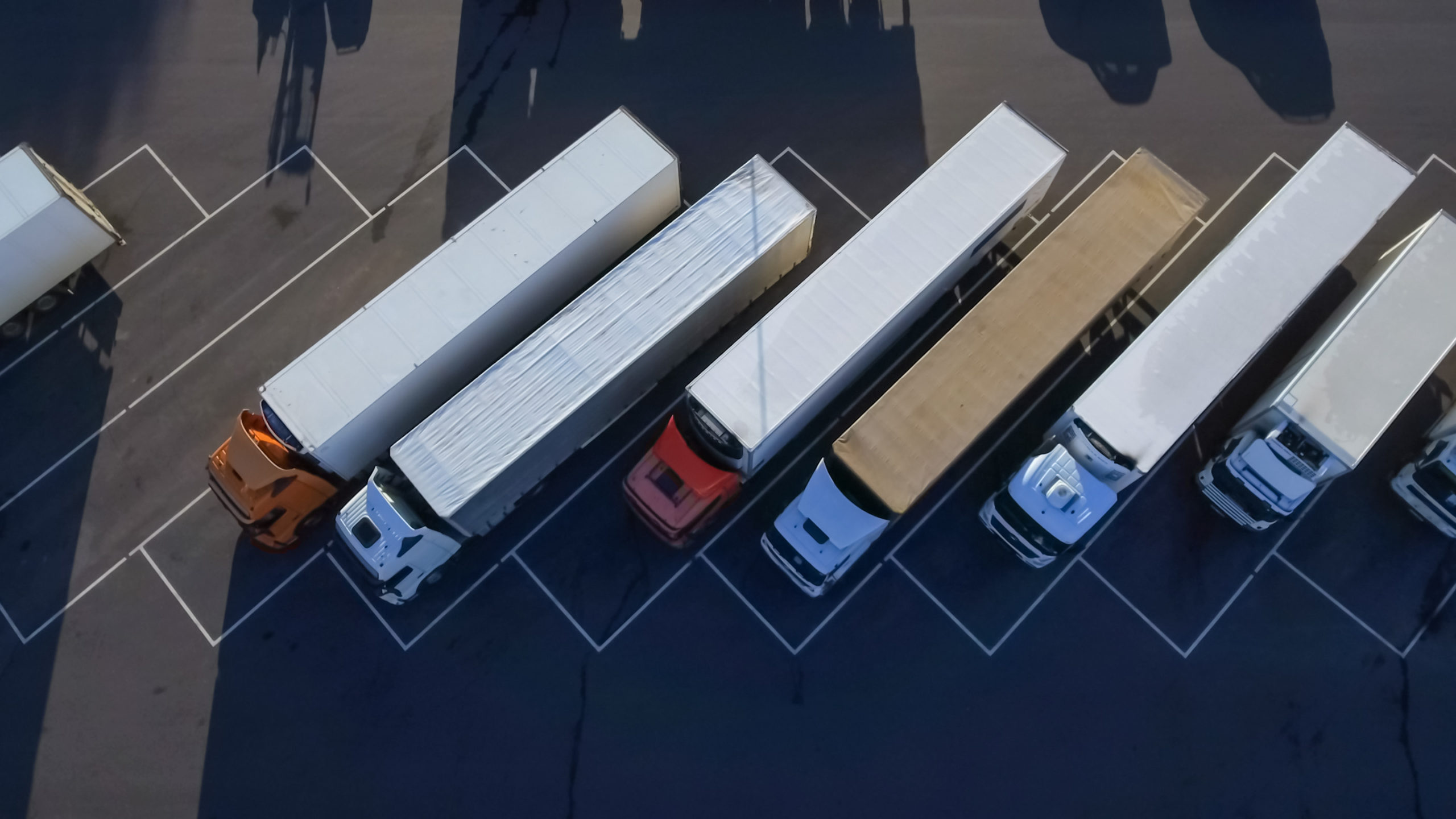 Aerial top view of white semi trucks with cargo trailer